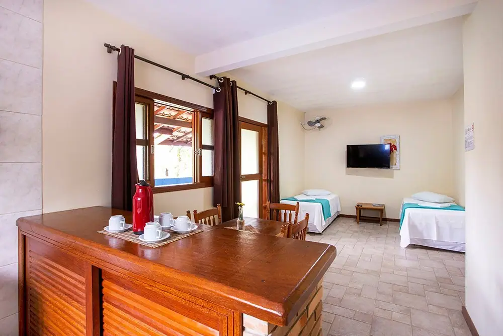 Sala do Apartamento da Pousada Villa Blu, em Maresias, com mesa de jantar