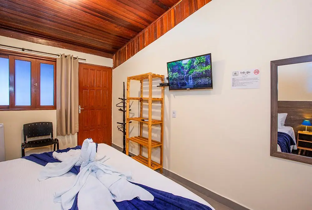 Suíte Standard com cama king, janela de madeira e smart TV